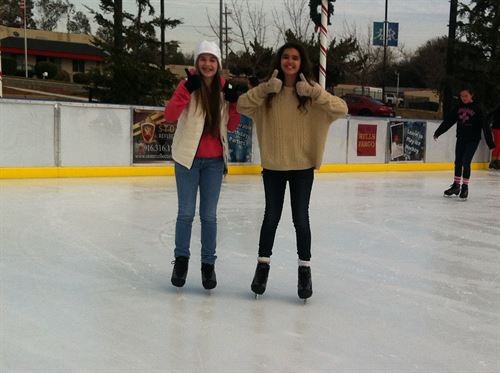 two woman on ice skates posing for photo